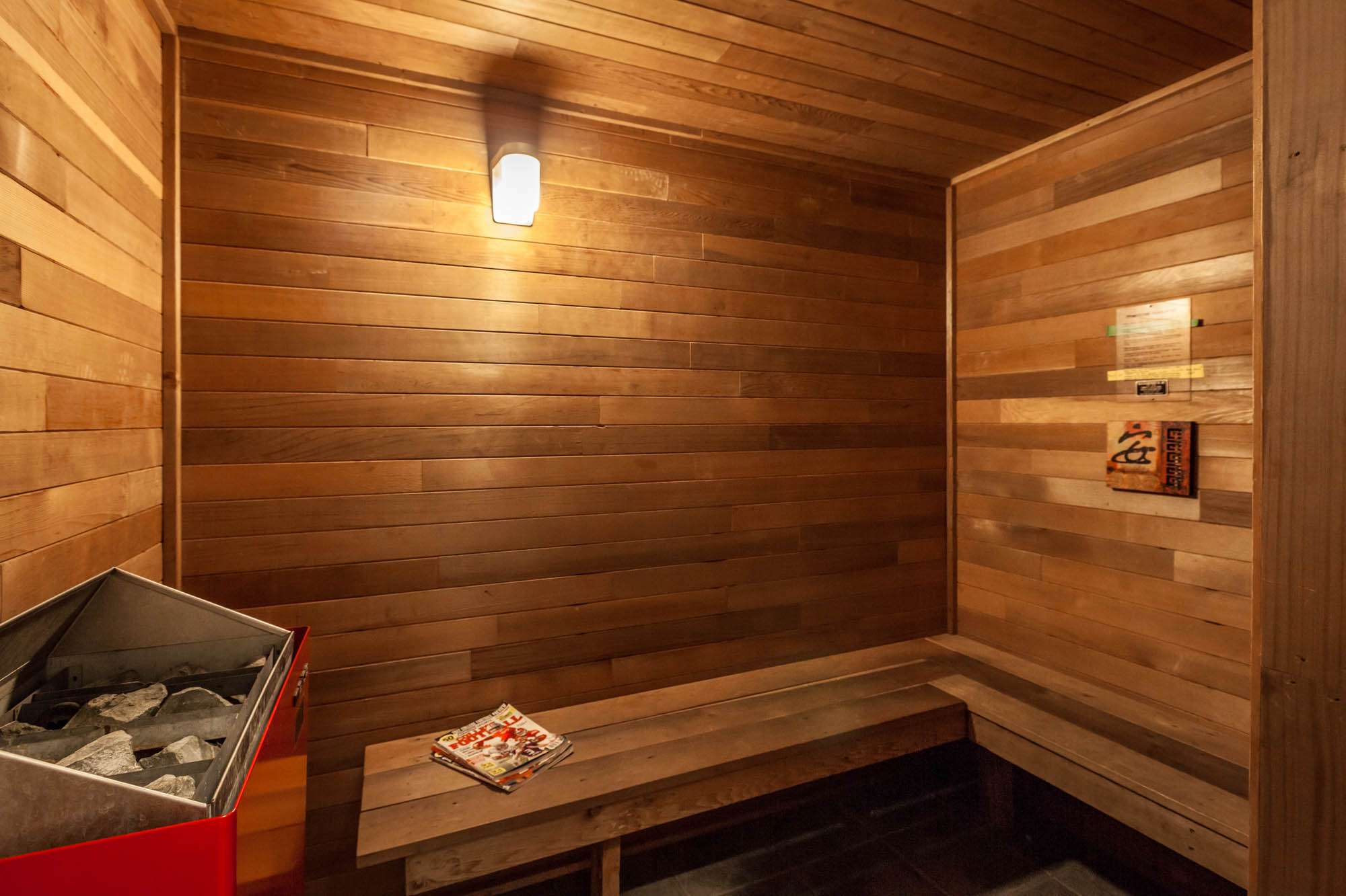 Wooden sauna room with bench and heater