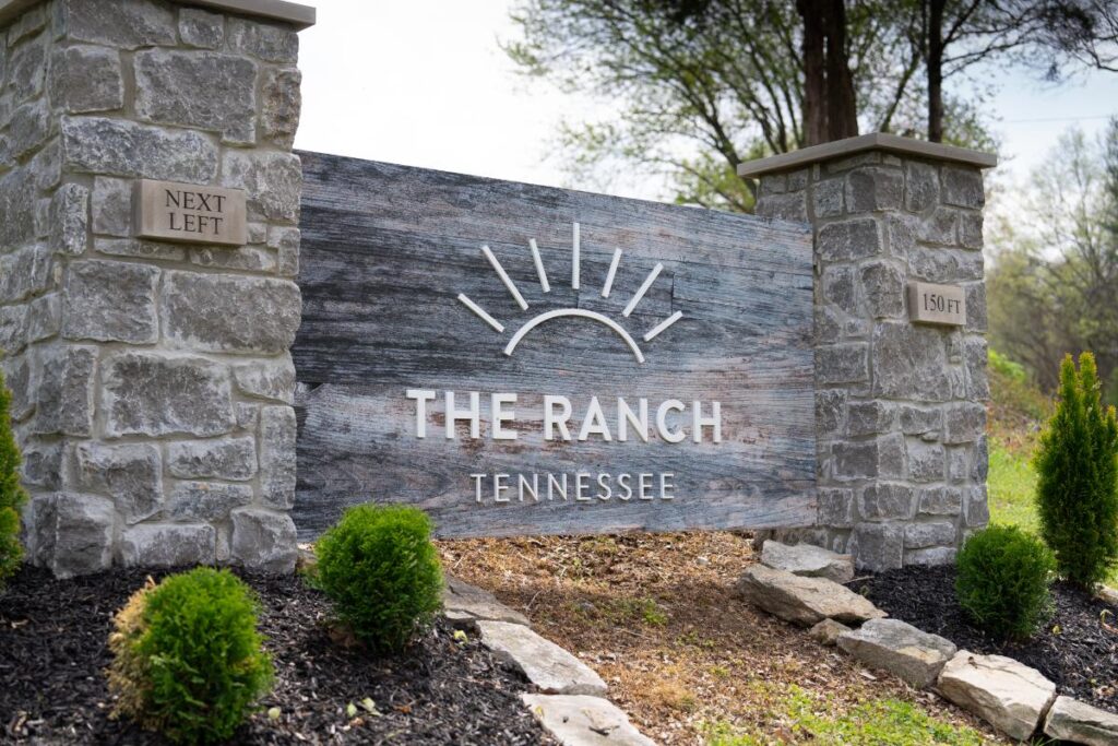 Stone sign structure displaying “The Ranch Tennessee” at the facility entrance with greenery around