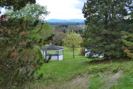 Gazebo in grassy yard with trees and mountain views
