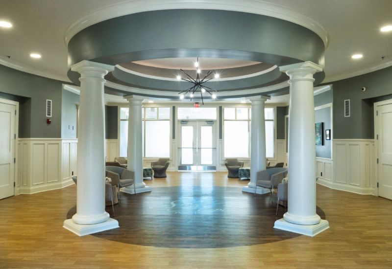 Lobby with white columns, circular ceiling, and wood floors