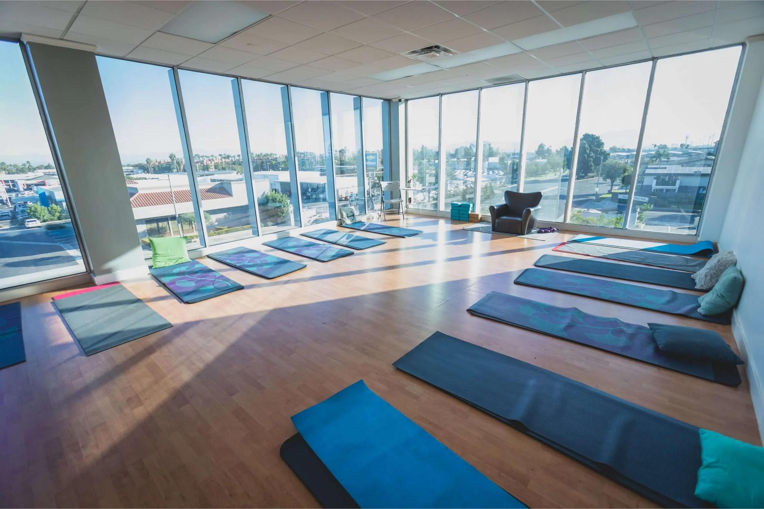 Yoga studio with large windows and mats.