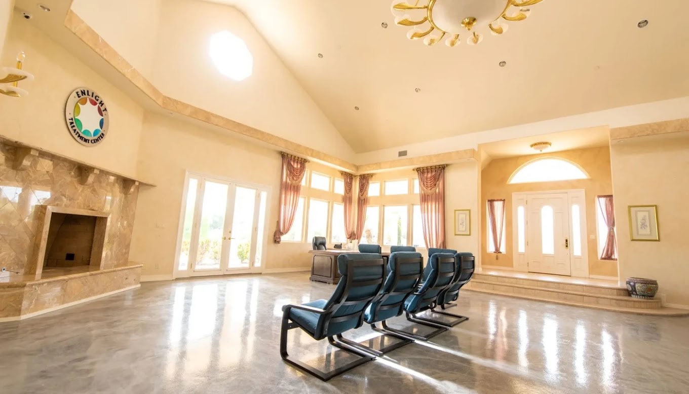 High-ceiling lobby with blue chairs and fireplace