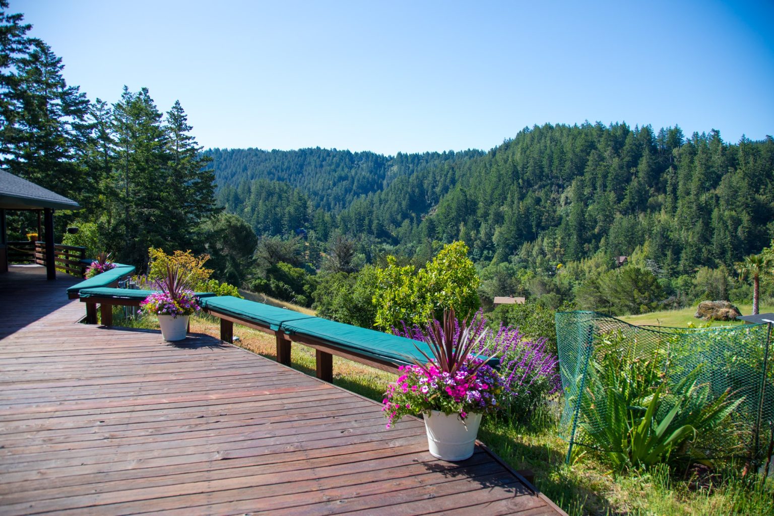 Wooden porch with seating overlooking forested hills