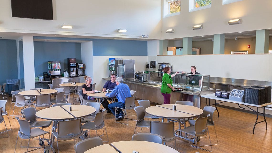 Cafeteria with round tables and food service area