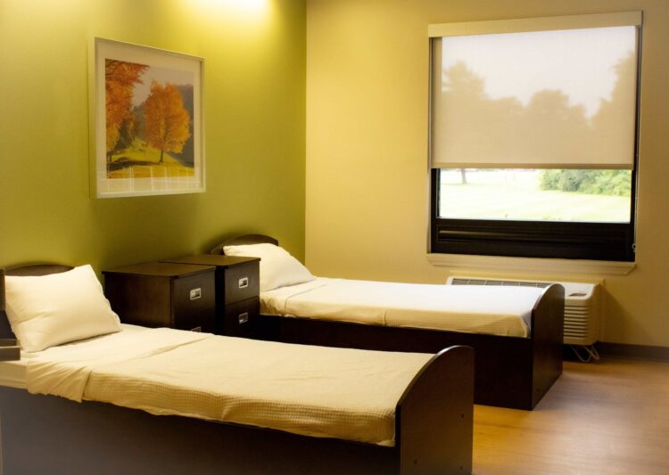 Two twin beds with window and autumn artwork