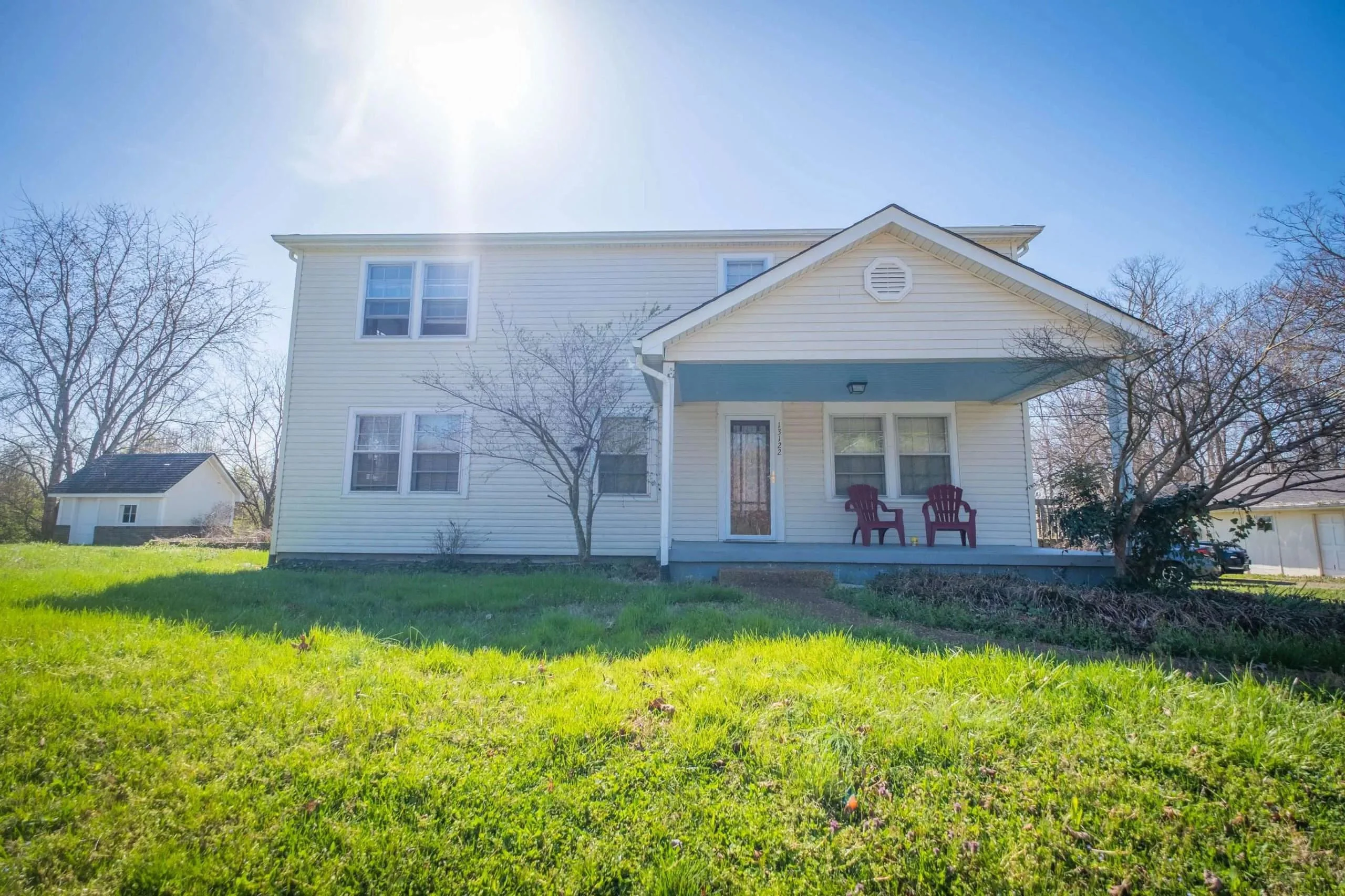 White two-story house with a front porch.