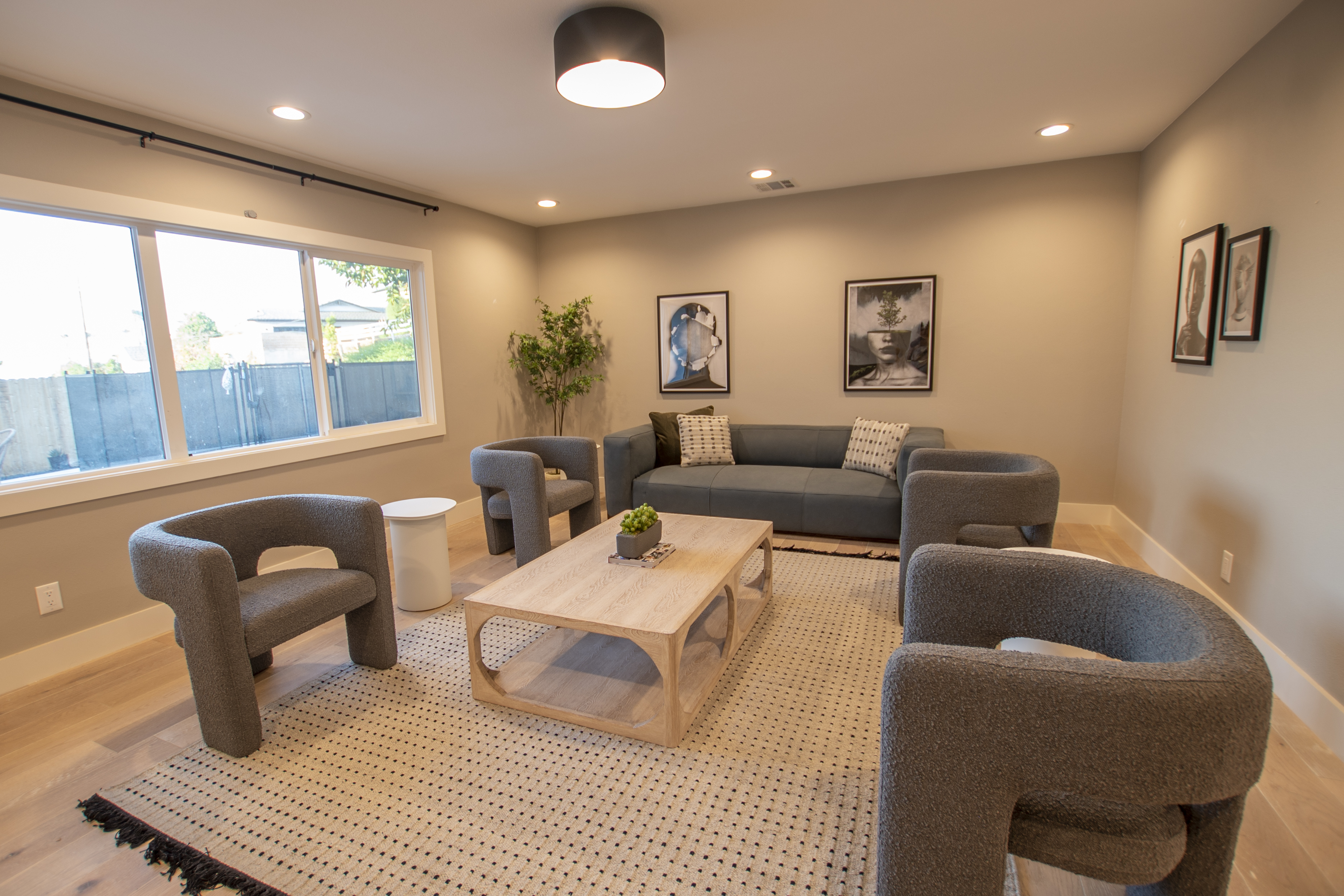 Lounge with gray chairs, sofa, and modern artwork