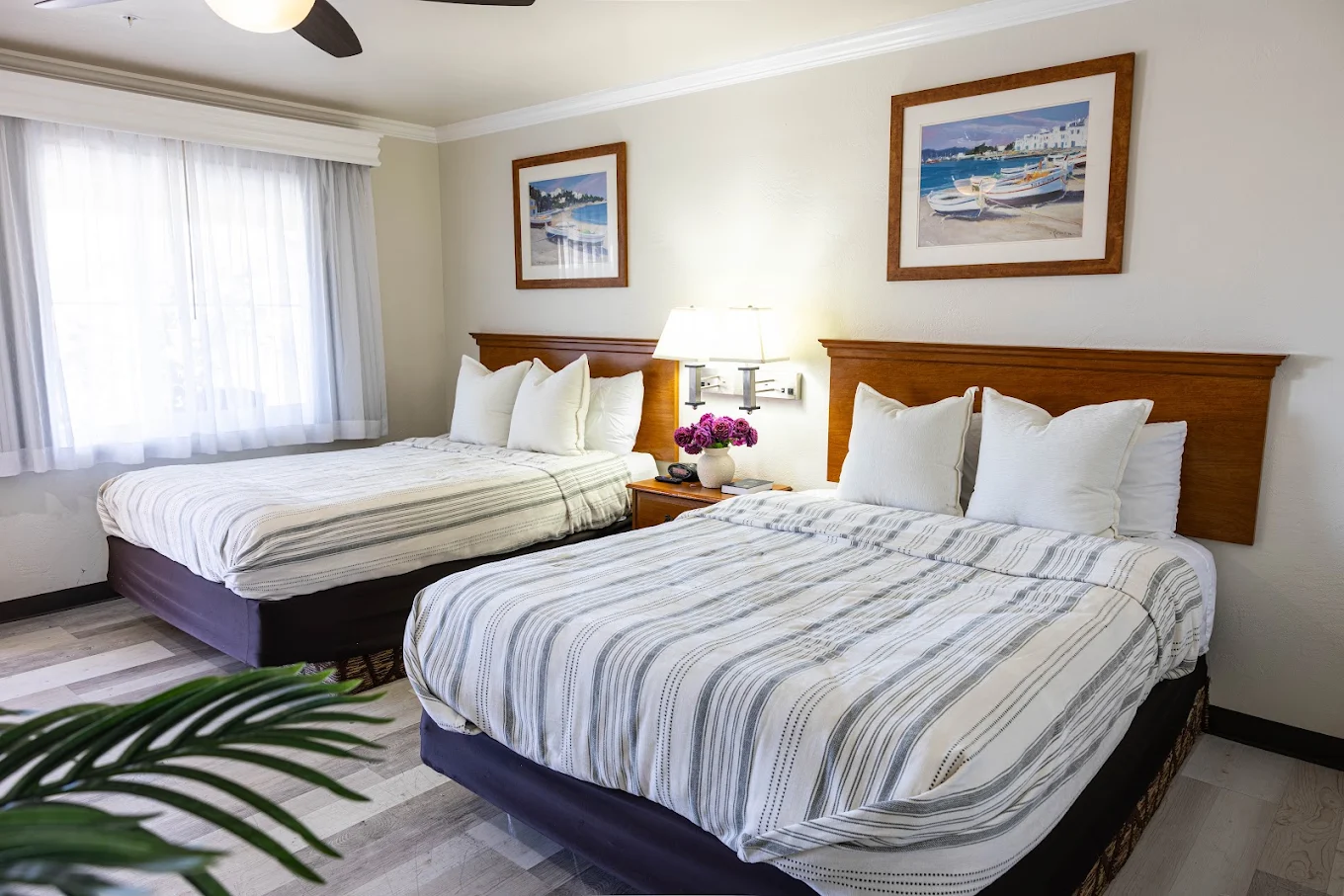 Bright shared bedroom with two beds and framed wall art