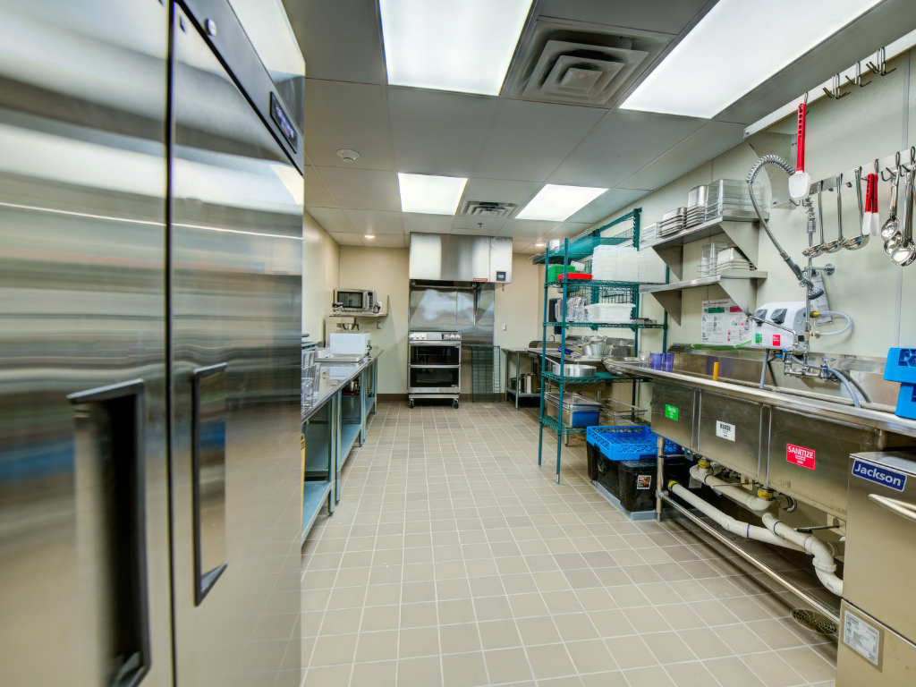 Stainless steel kitchen with industrial appliances and storage