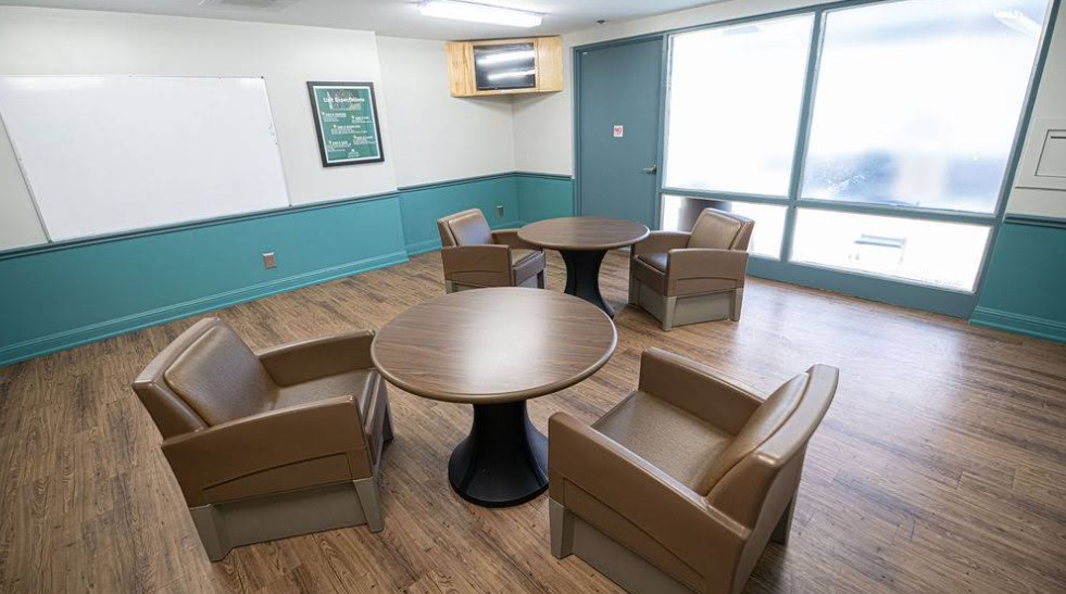 Group therapy room with tables and lounge chairs