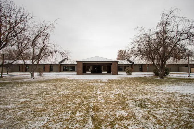 Single-story brick building in winter with bare trees
