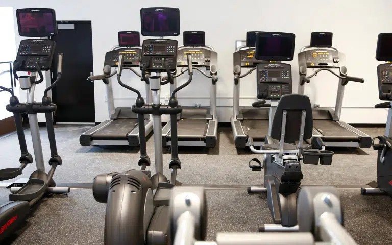 Gym with treadmills, ellipticals, and other exercise equipment.