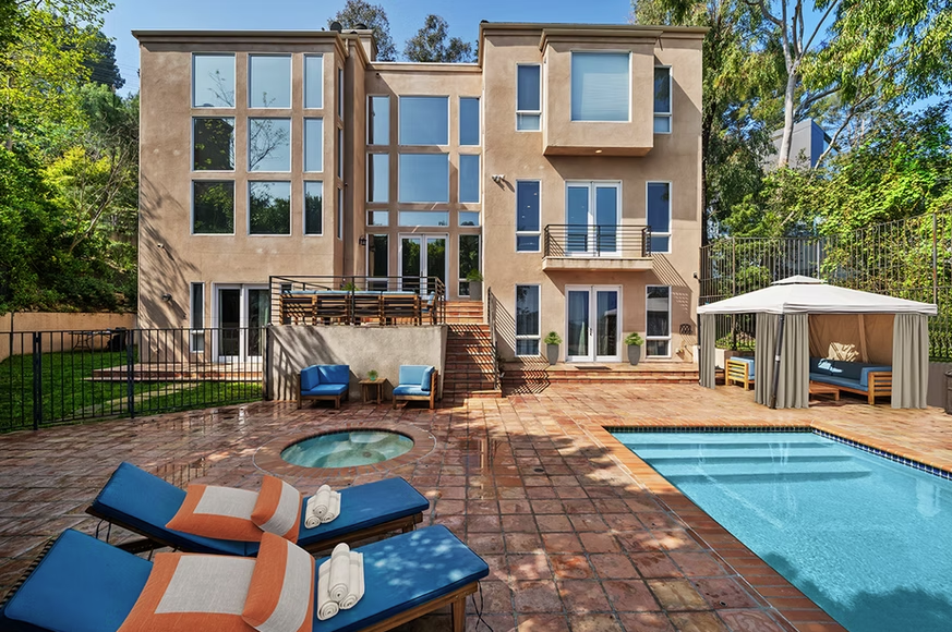 Pool area with cabana, lounge chairs, and tiled deck