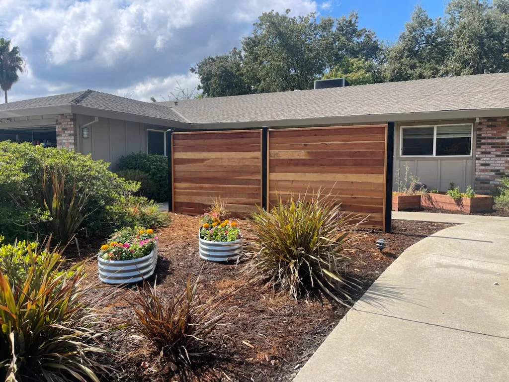 Garden beds and privacy fence outside residential rehab home