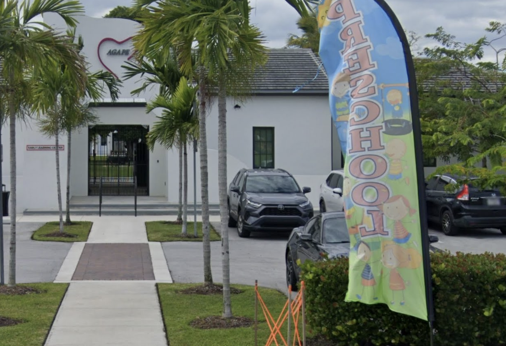 Agape facility entrance with palm trees and parking area