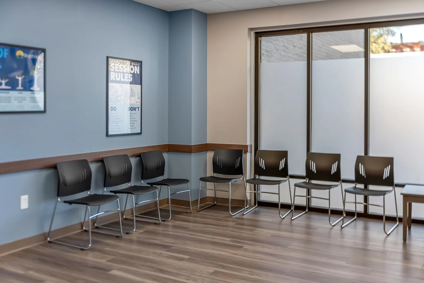 BrightView Health seating area with black chairs arranged along blue walls and large frosted windows