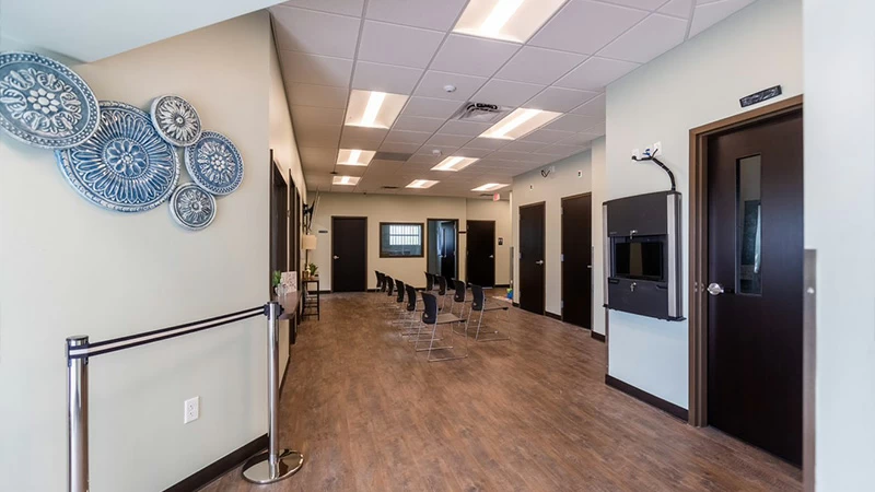 Long hallway with chairs and wall decor