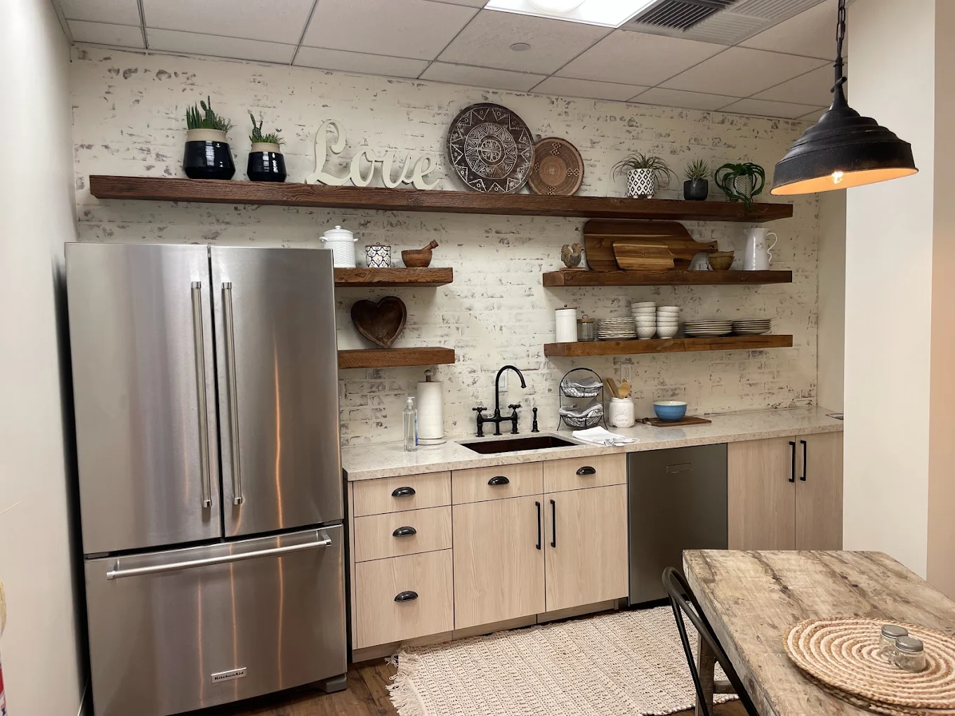 Open shelves with dishes above a farmhouse-style kitchen