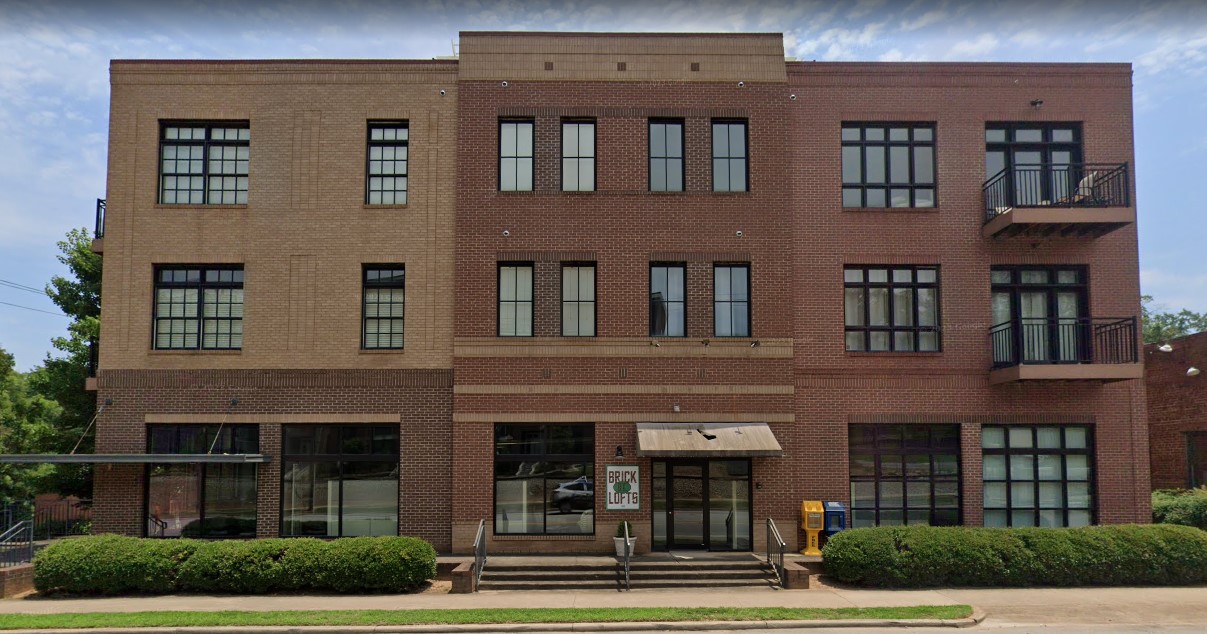 A front view of a modern brick rehab facility with black-framed windows