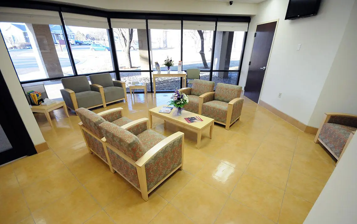 Round table with chairs in bright recovery lounge