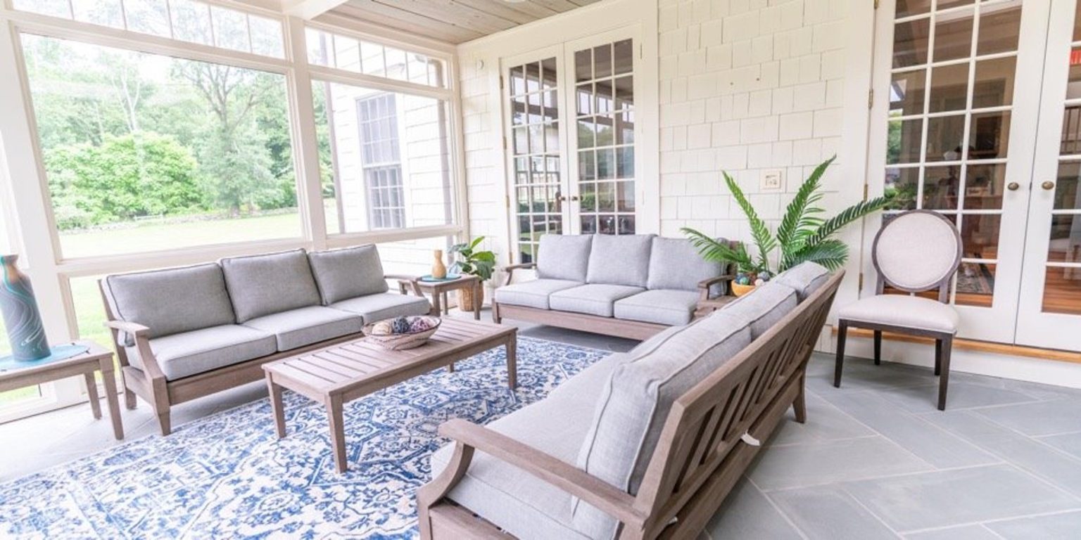 Bright sunroom with gray sofas and large windows