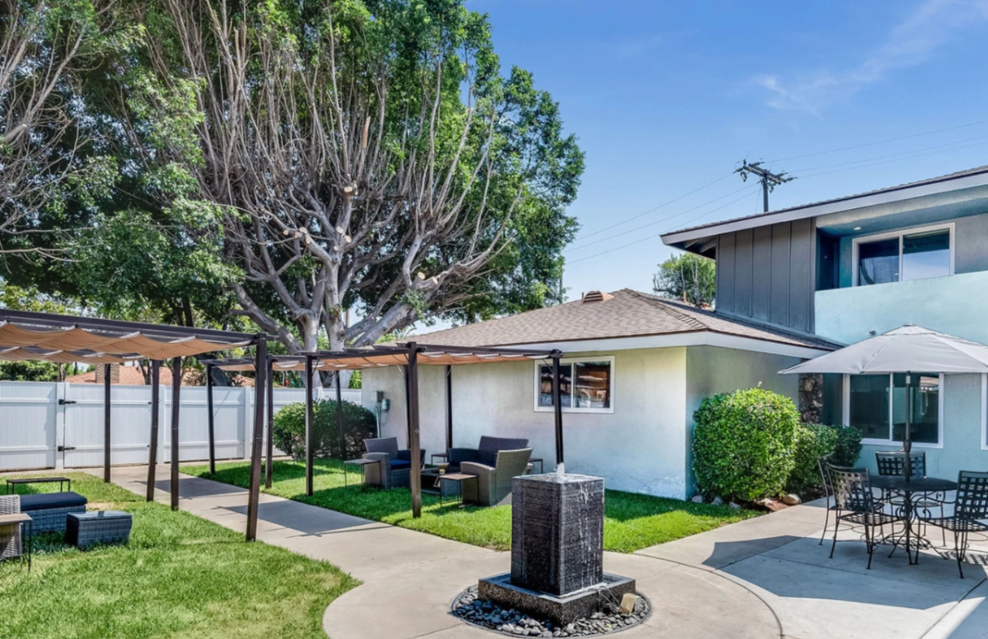 Outdoor seating area with pergola and greenery.