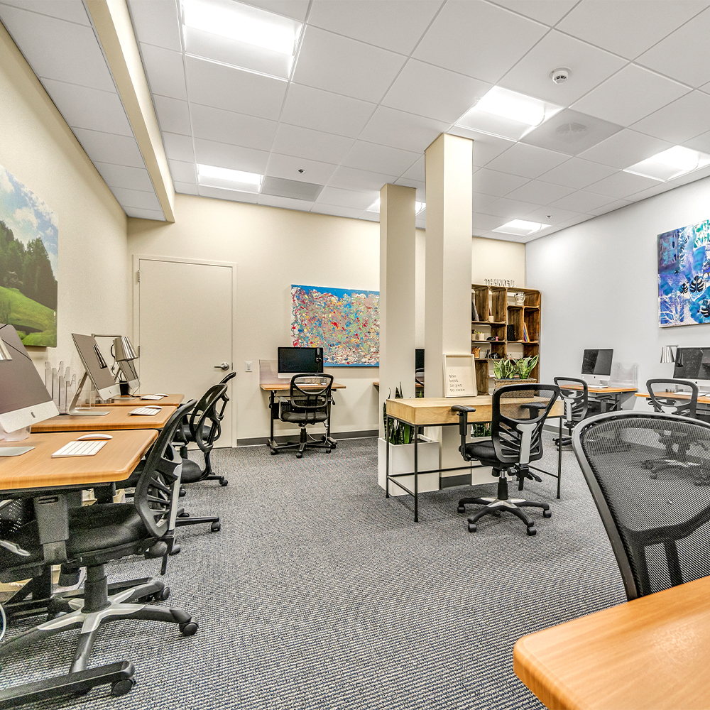 Workspace with multiple computer stations and chairs.