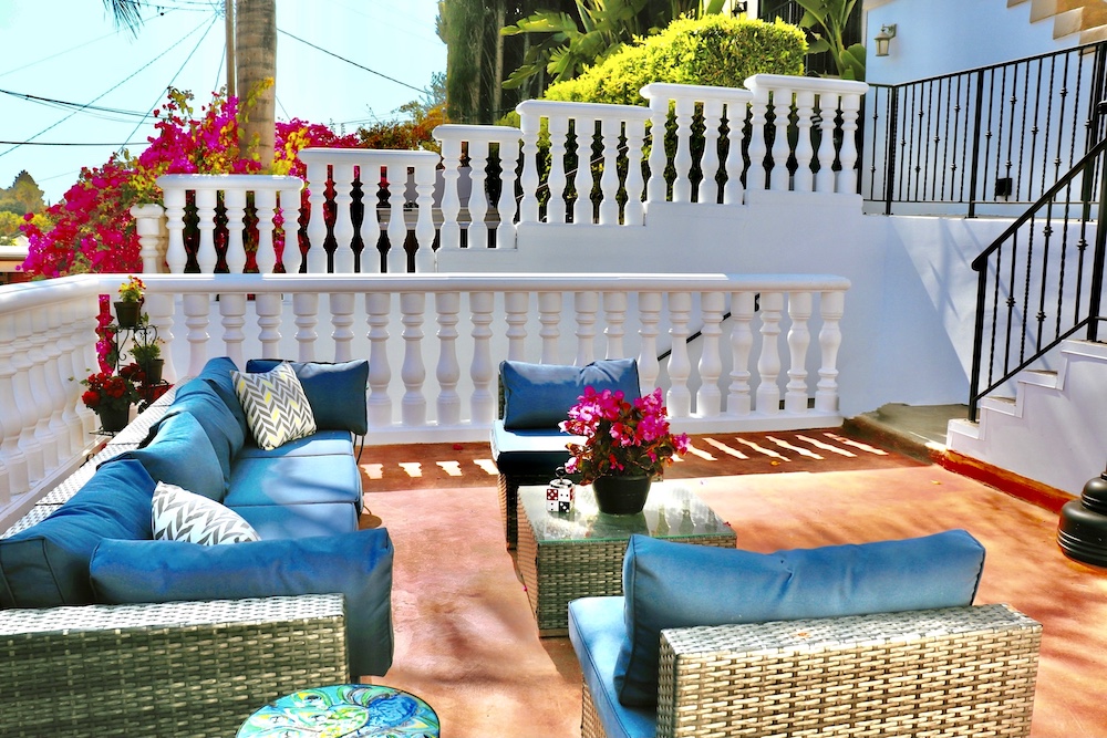 Outdoor patio with blue cushioned seating and potted flowers