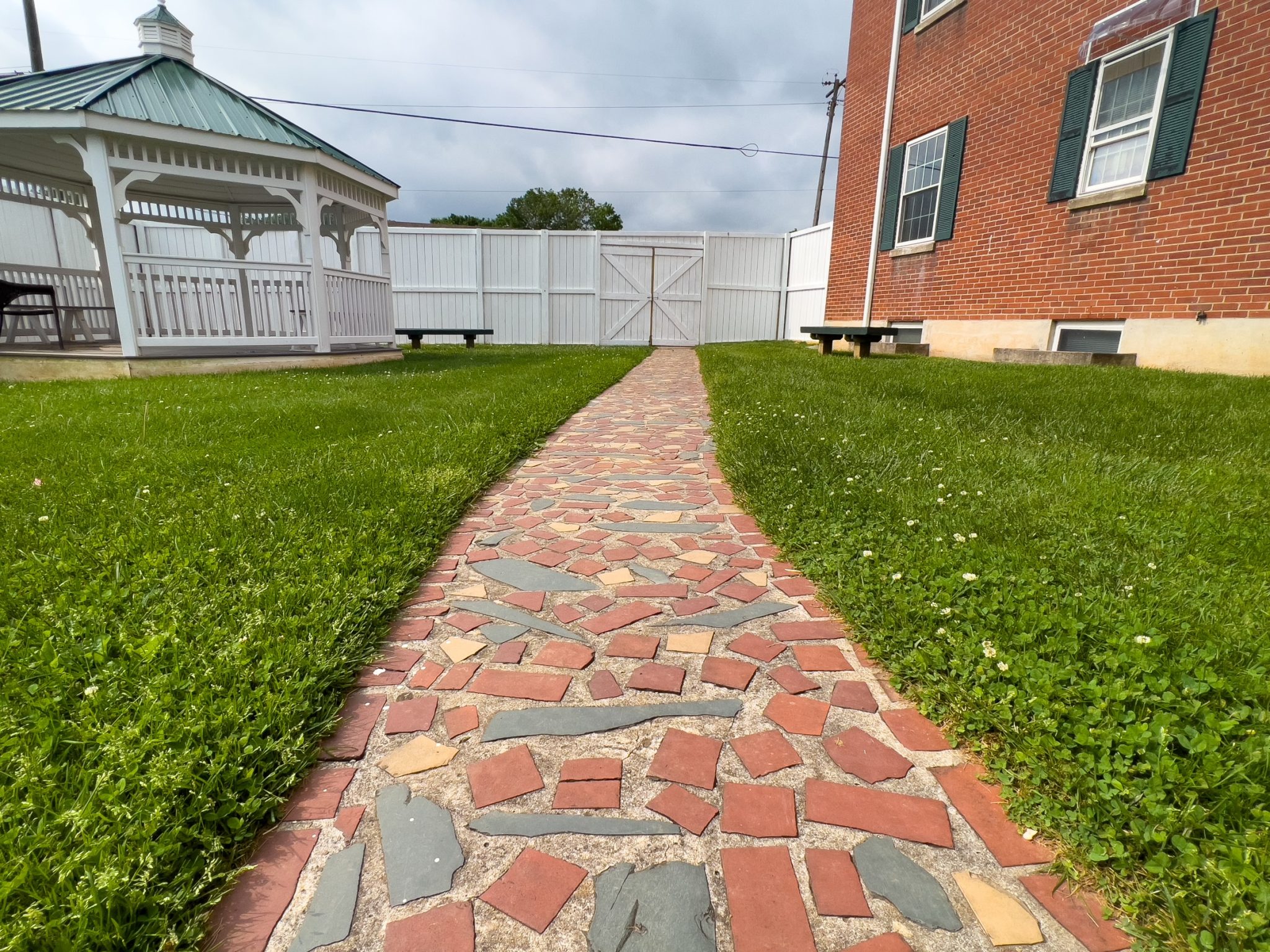 Stone walkway across the lawn leading to a white gazebo