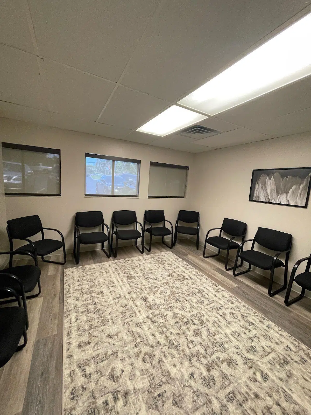 Circle of chairs in a carpeted room with windows