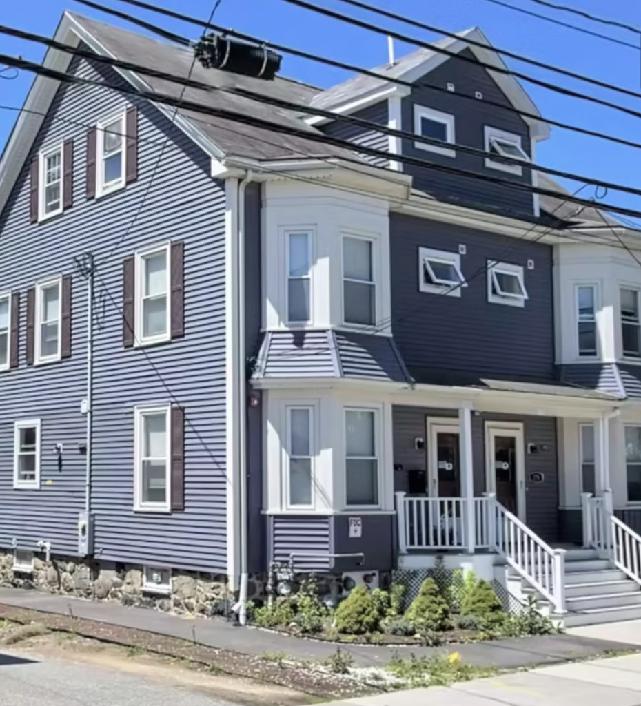 Three-story gray home with white trim and front porch