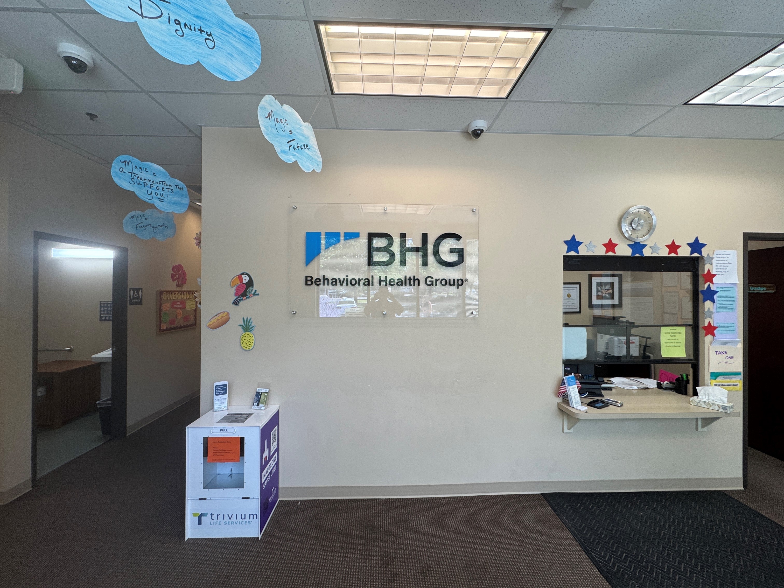 Lobby reception area with check-in window and BHG wall sign