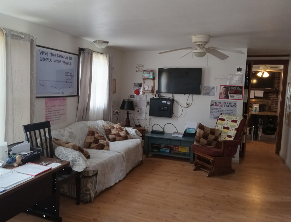 Living room with couch, TV, and info posters