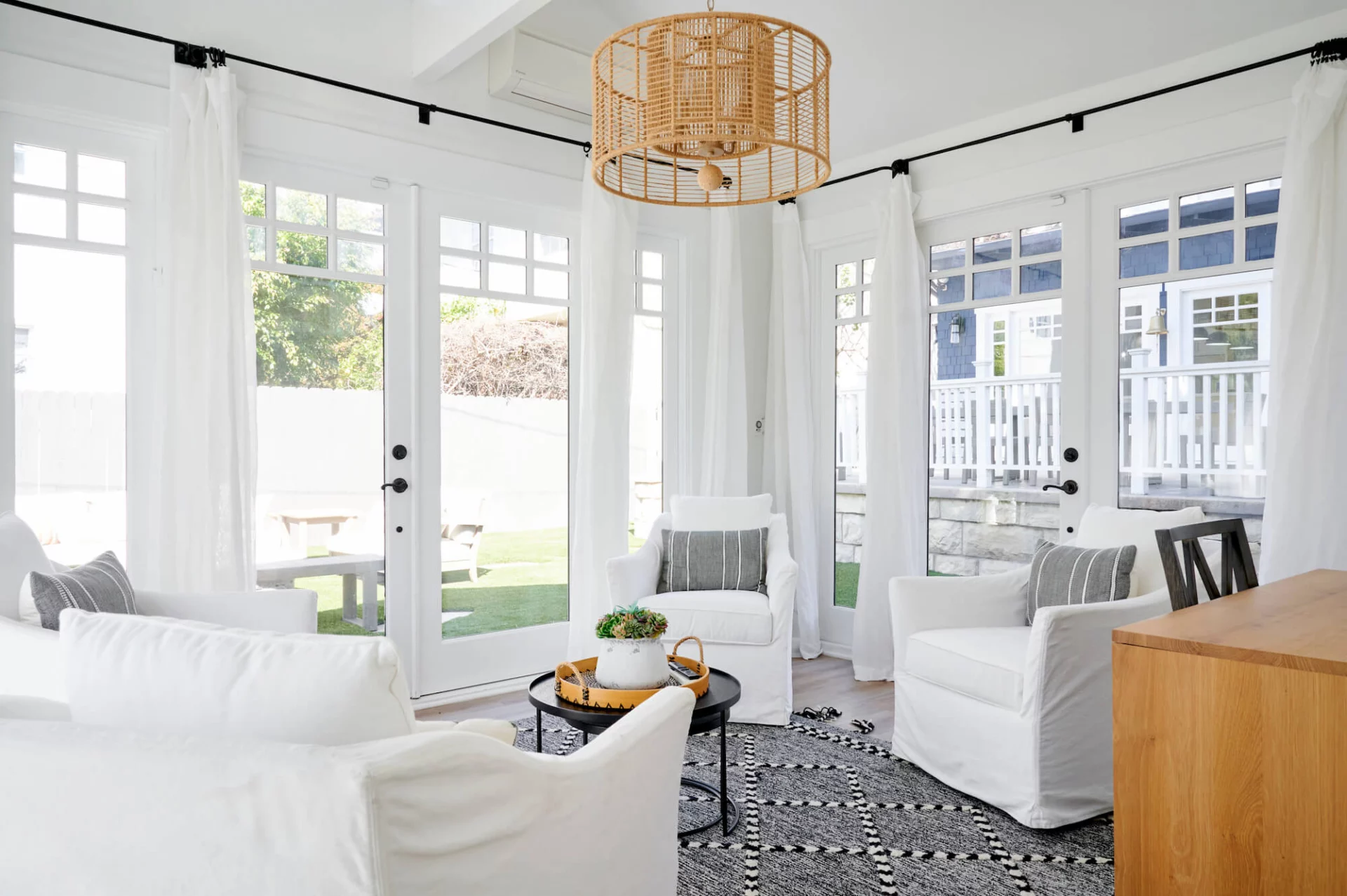 Cozy lounge with white chairs and patio access