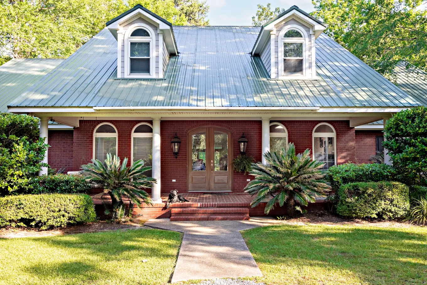 Brick home exterior with front walkway and greenery