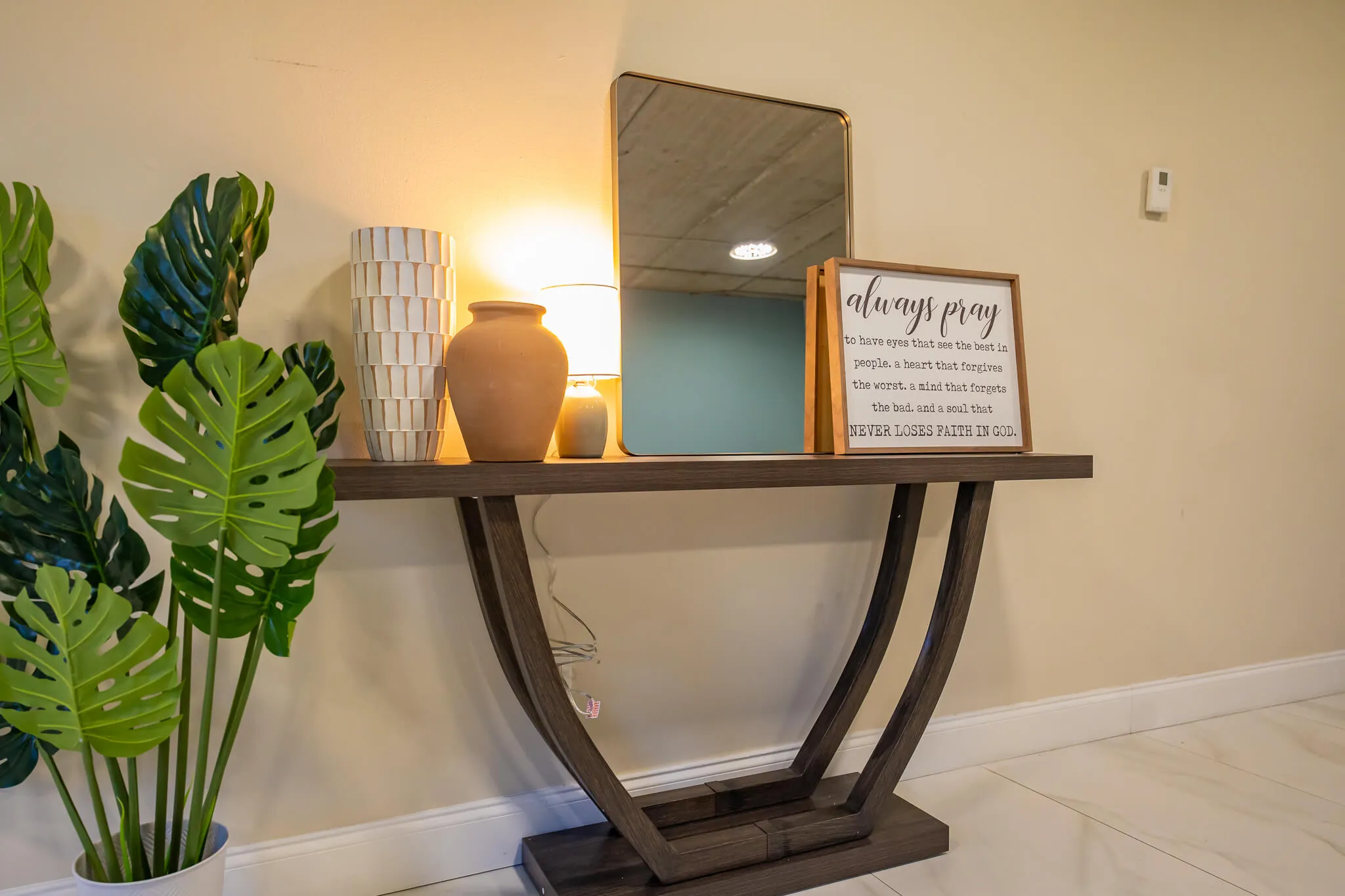 Console table with mirror, plants, and decorative items