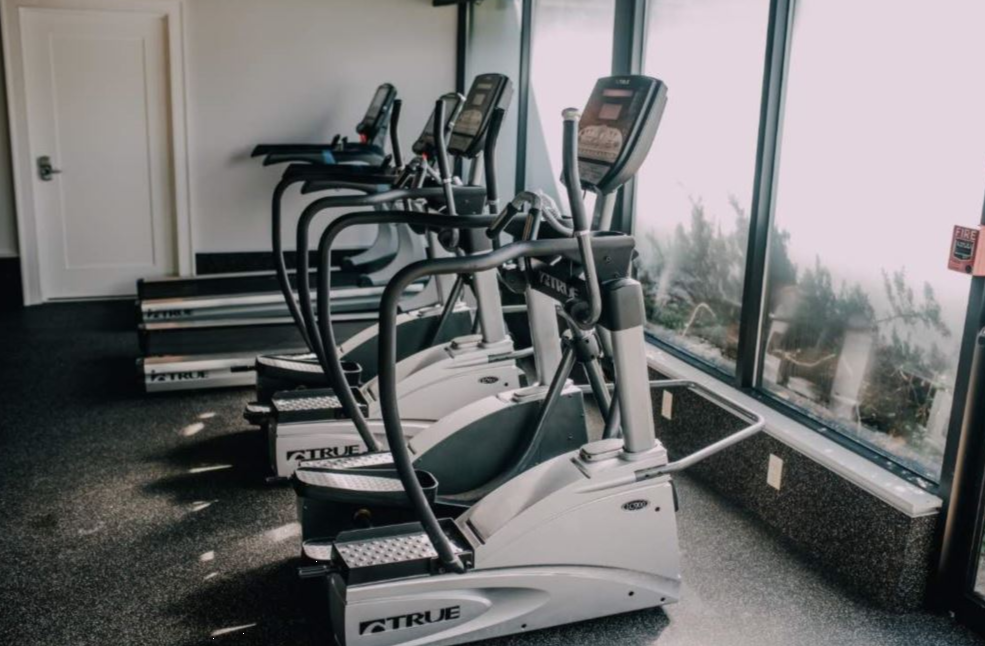 Row of elliptical machines in a bright fitness room