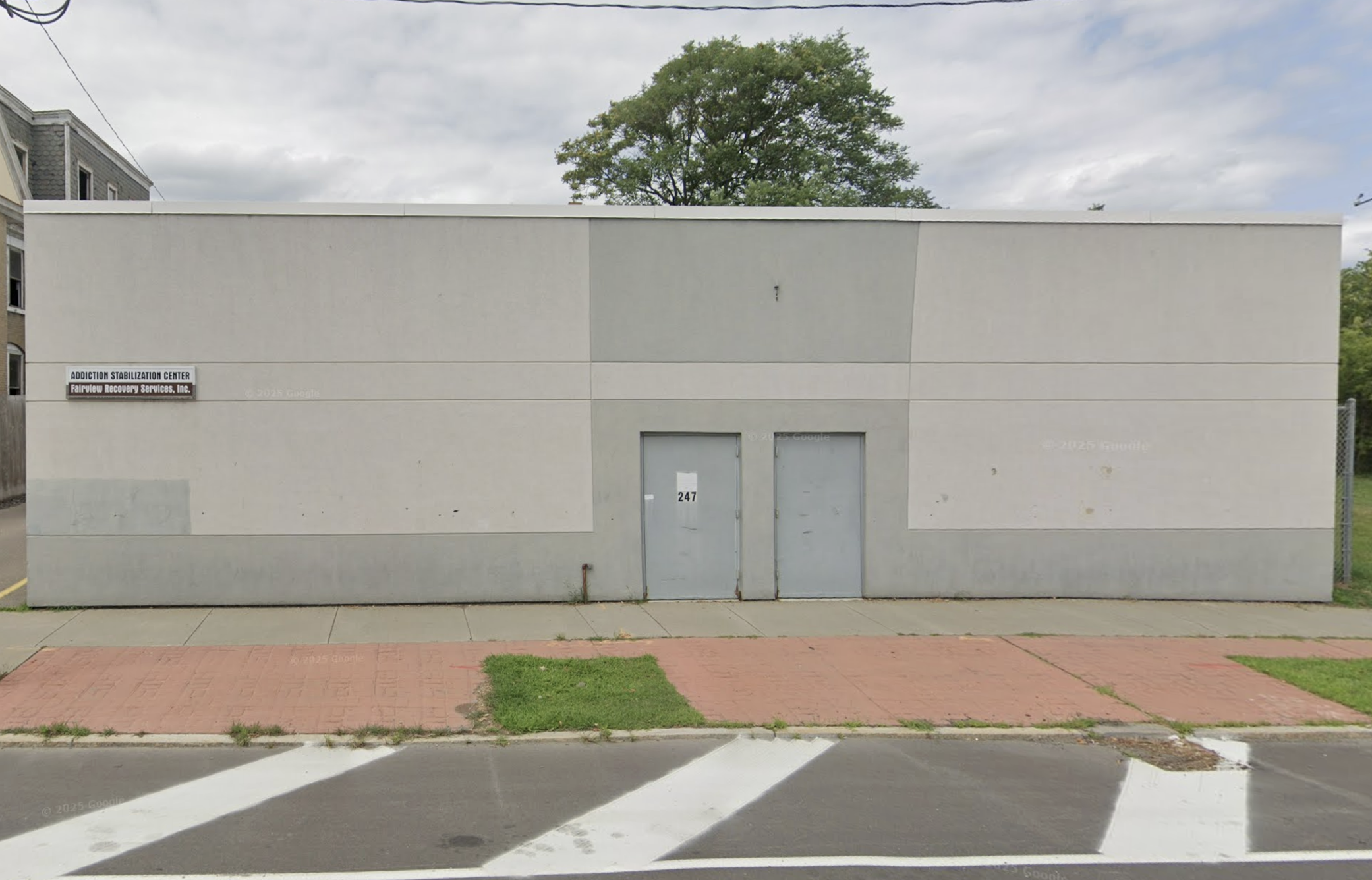 Front of rehab center with double gray doors and sign