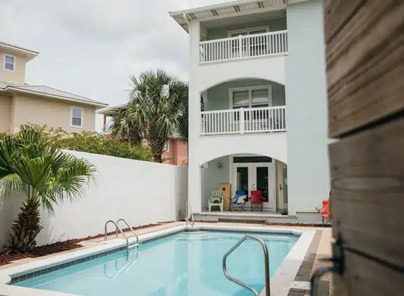 Backyard swimming pool beside three-story building