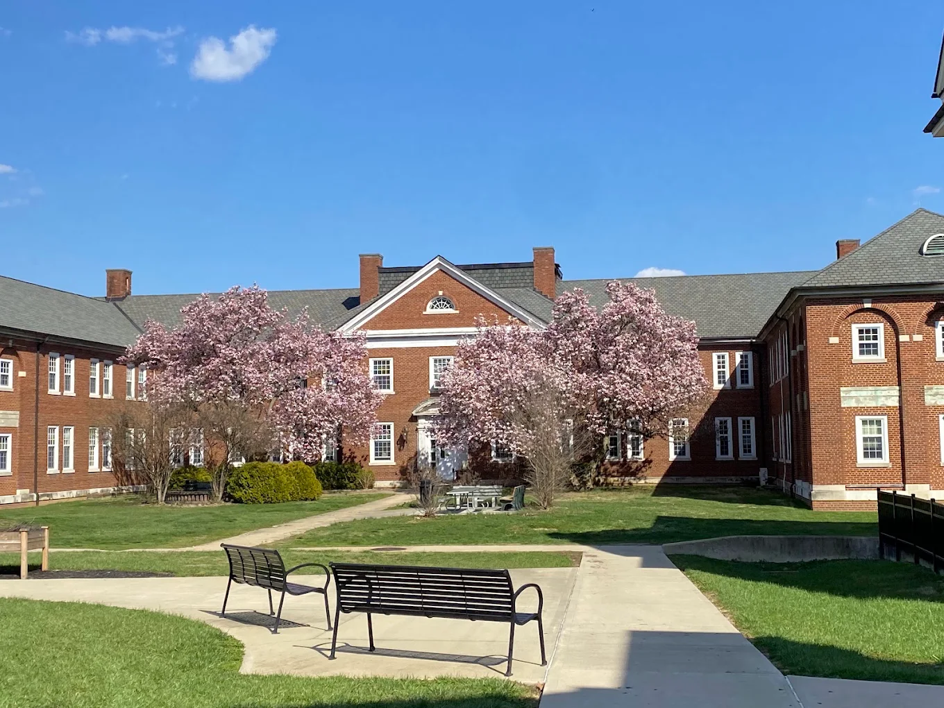 Brick VA medical center courtyard with benches and flowering trees