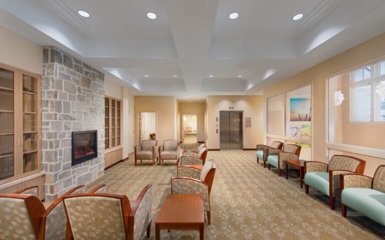 Comfortable lounge with chairs, fireplace, and elevator