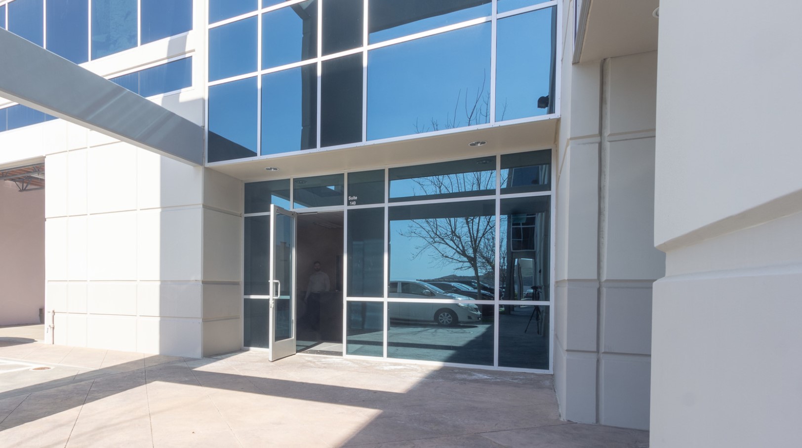 The entrance to the facility features modern glass doors and sleek design elements, creating a professional and accessible entryway.