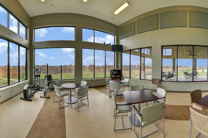Bright room with tables, chairs, and exercise machines
