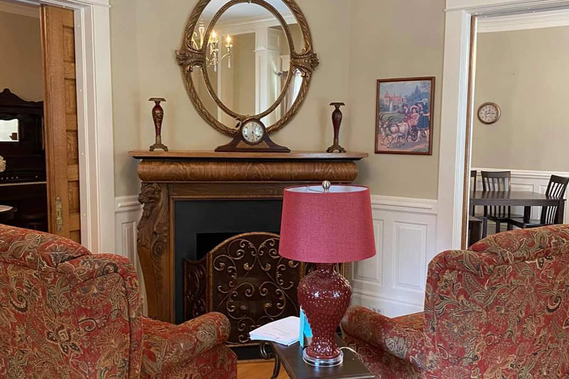 Fireplace lounge with ornate mirror and armchairs