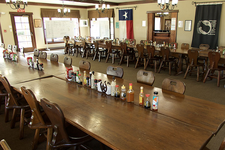 Large dining room with long tables and Texas flag on the wall