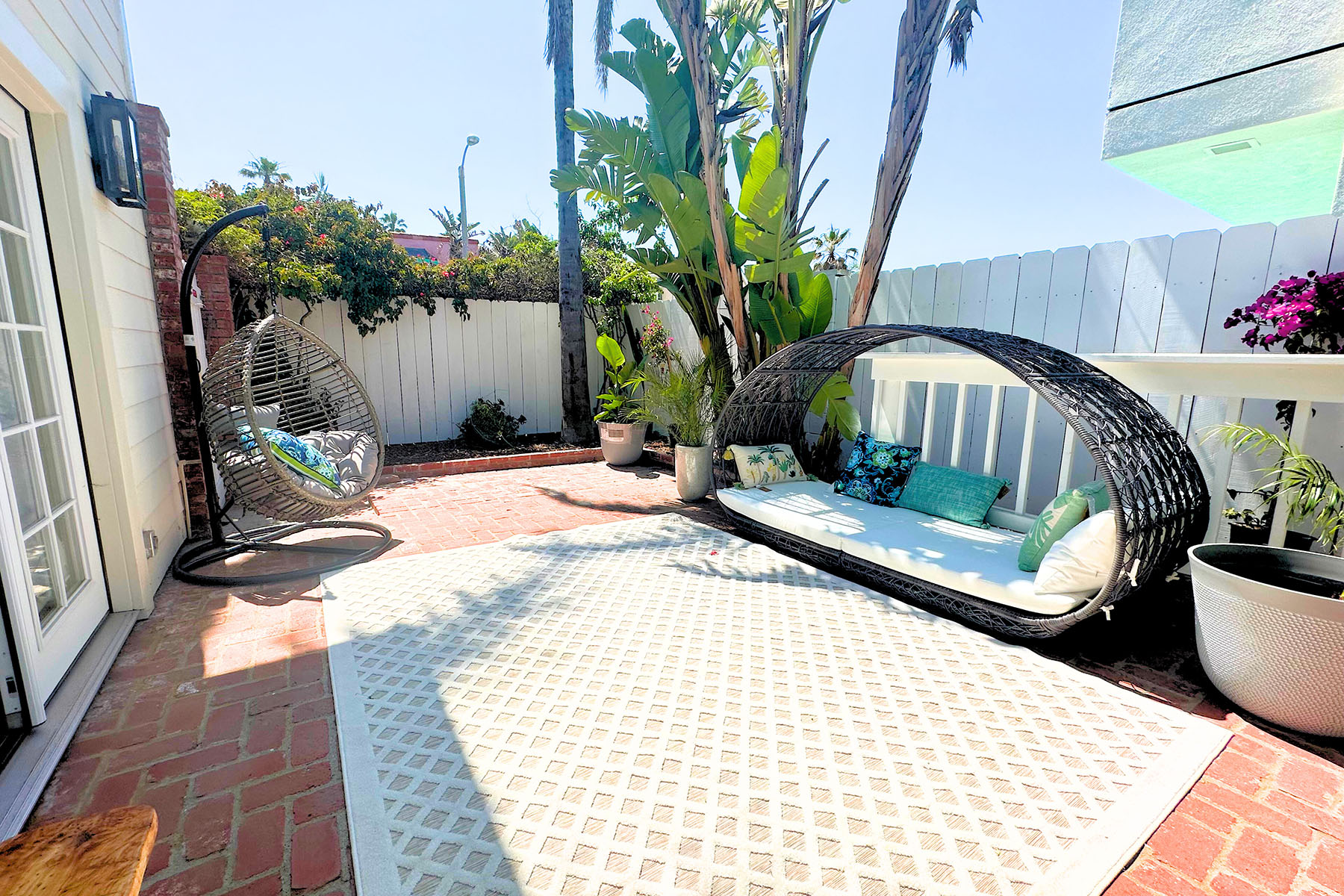 Outdoor lounge with hanging chair and wicker daybed