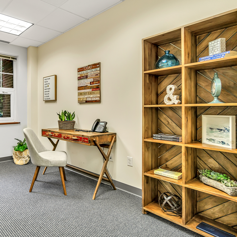 Office space with a desk, chair, and bookshelf.