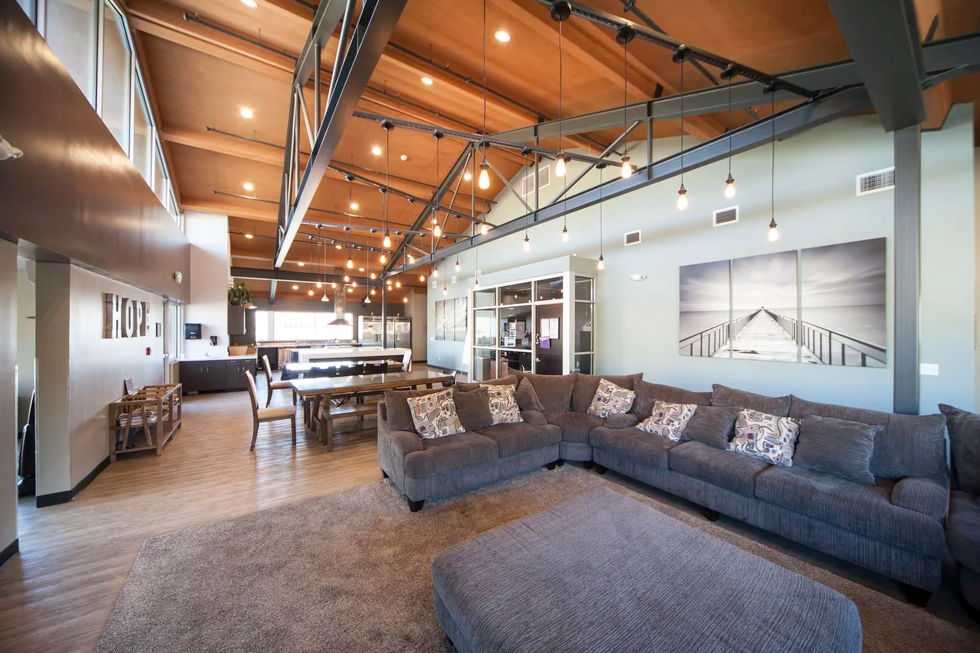 Spacious communal living room with sofas and high ceilings