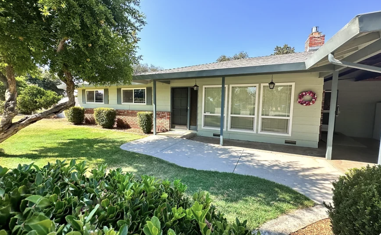 Outdoor unit view with landscaped yard paved to entrance.