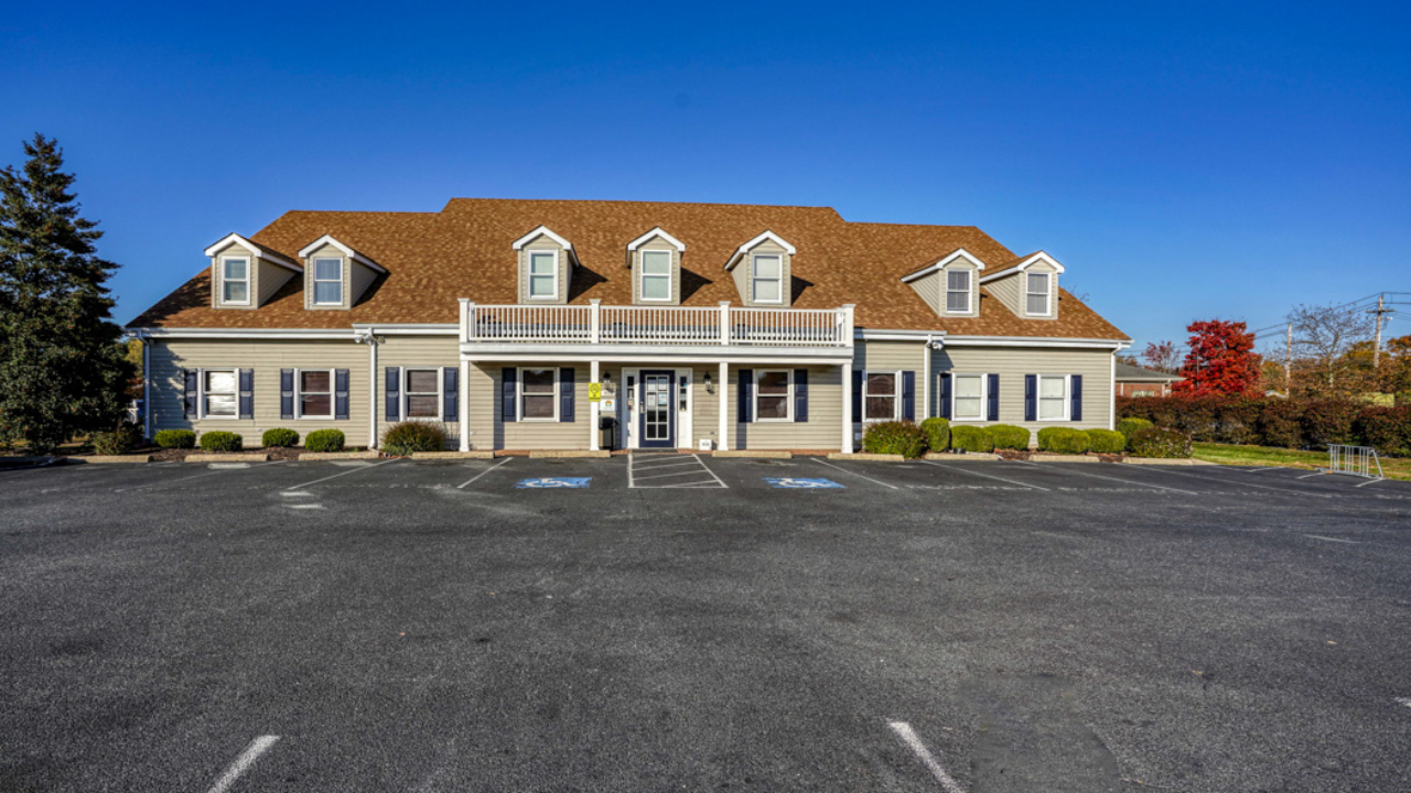 Exterior of BrightView Health Easton with beige siding, brown roof, covered entrance, accessible parking spaces, and large parking lot